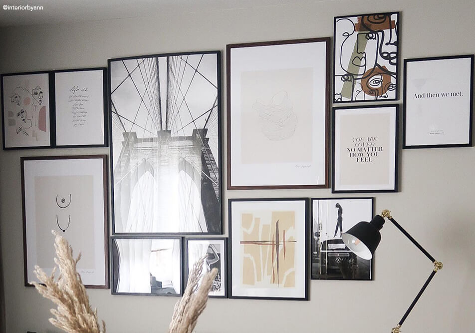 Veliki zid s okvirima iznad sofe u dnevnoj sobi